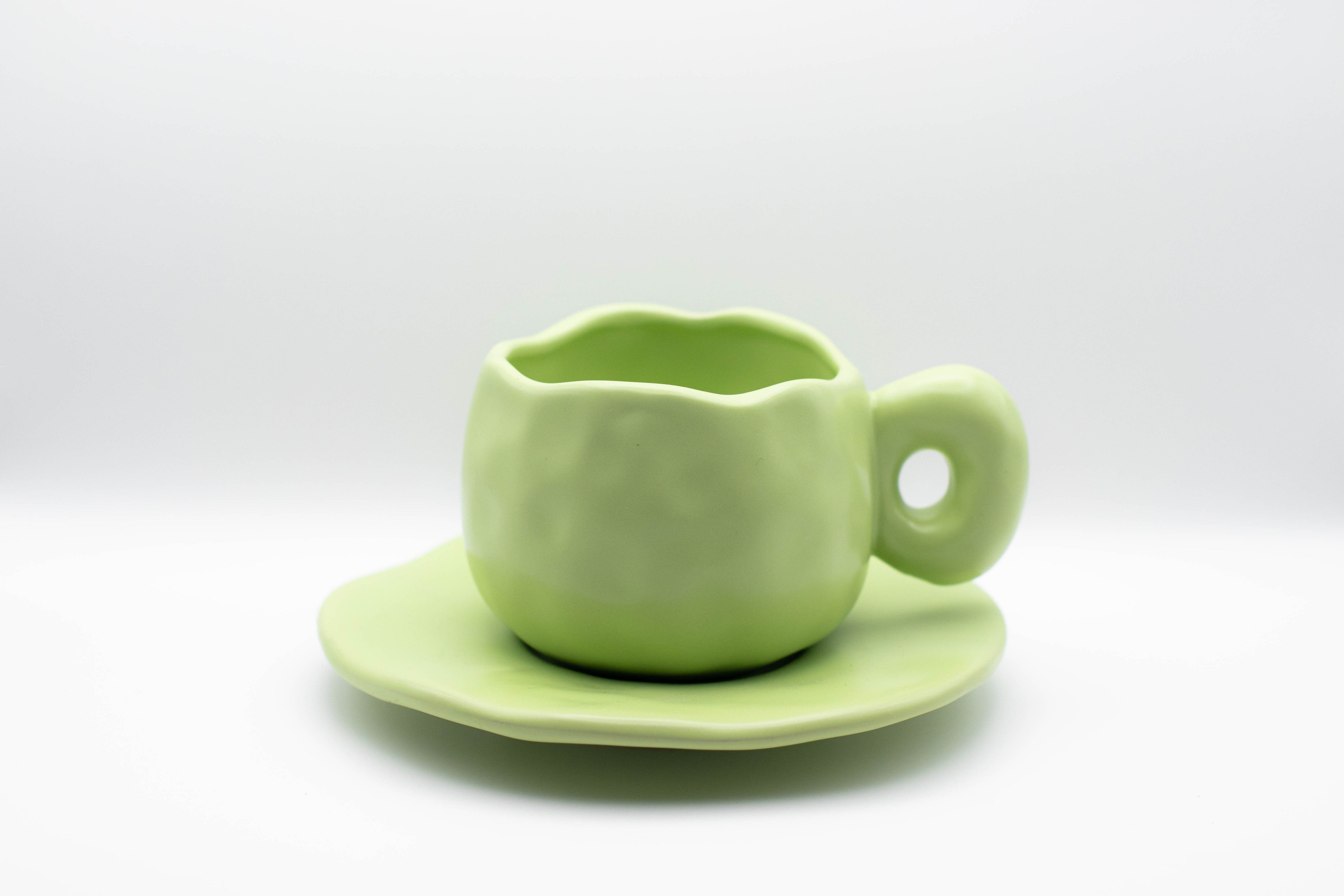 Stand-alone picture of our ceramic Curve cup in a soft pastel green color. 