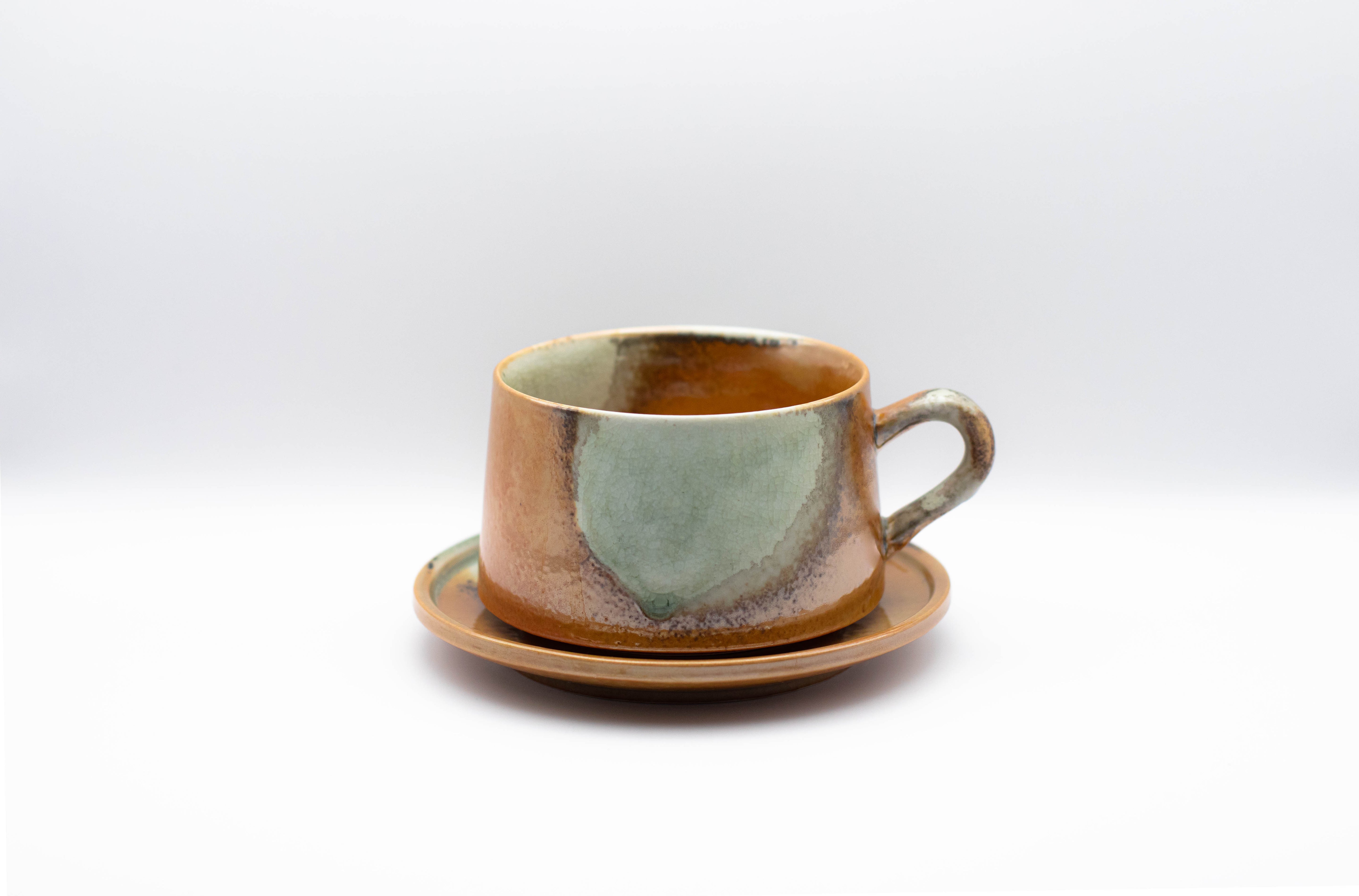 A stand-alone product picture of our ceramic cup Vintage Charm, in a deep orange marble tint.