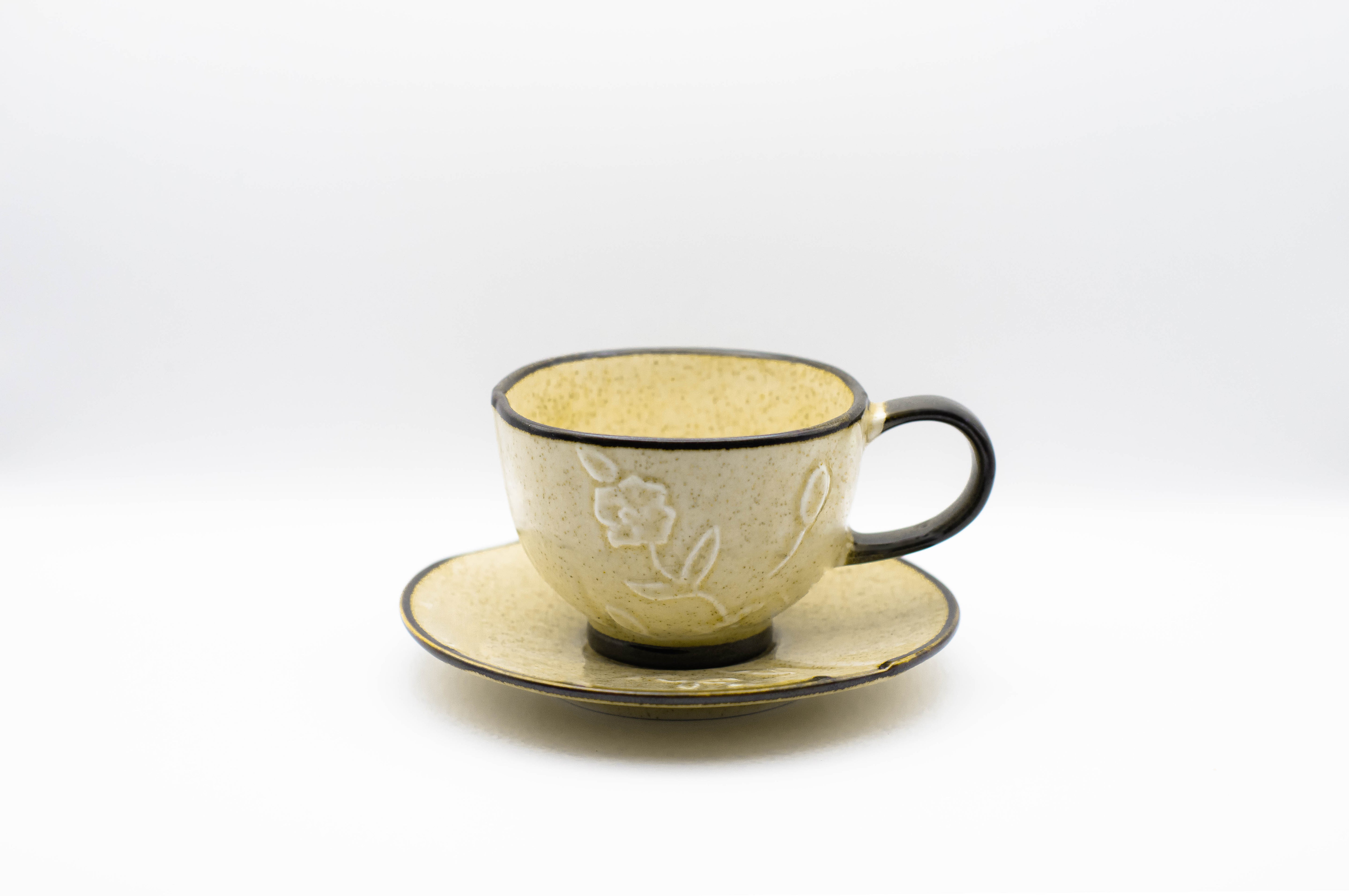 Stand-alone picture of our beige Hana Kasumi cup. A small cappuccino cup with flower relief, including saucer.