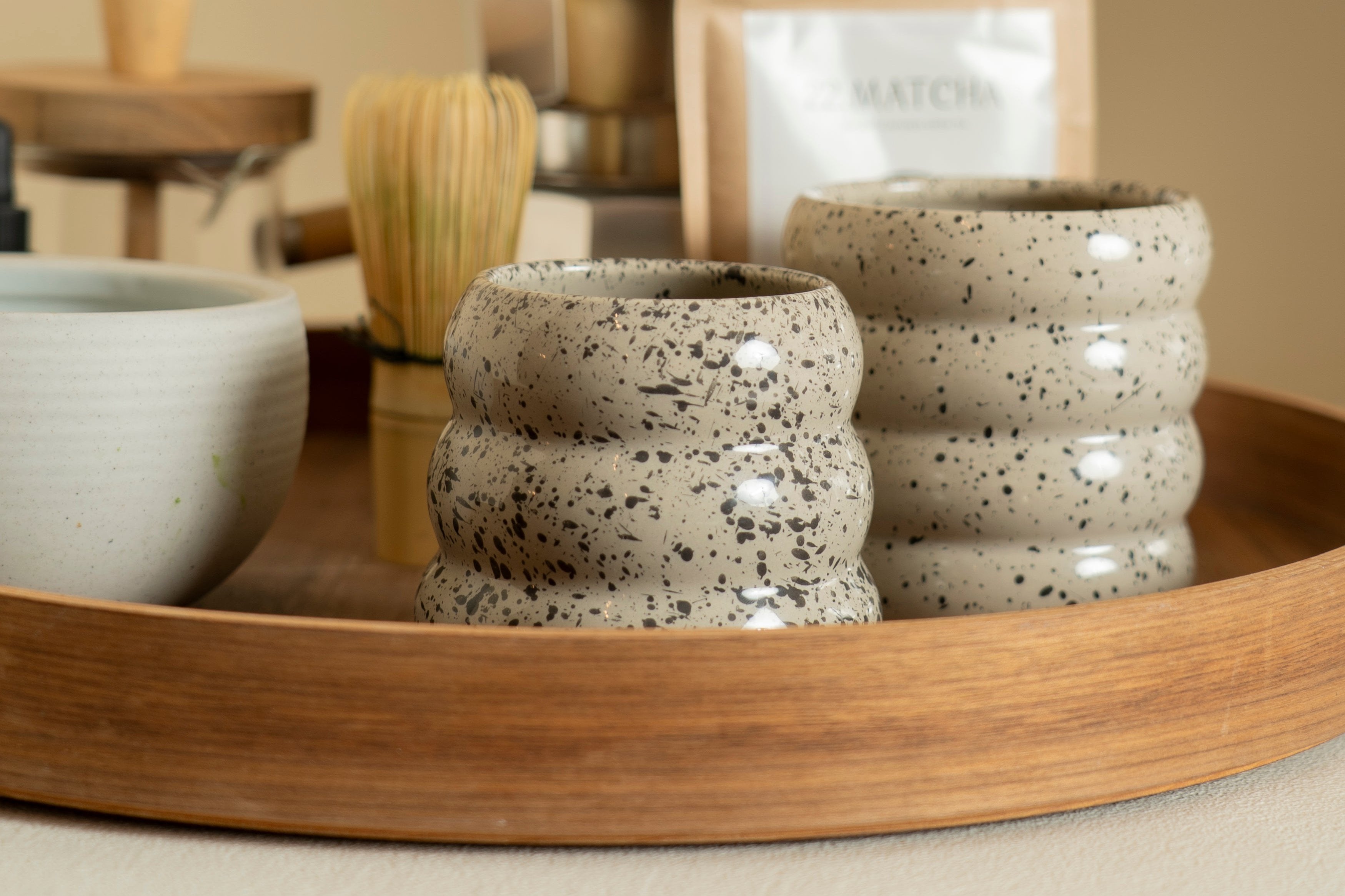 Our two layered sprinkled donut cups on a wooden platter with a matcha set on the background. 